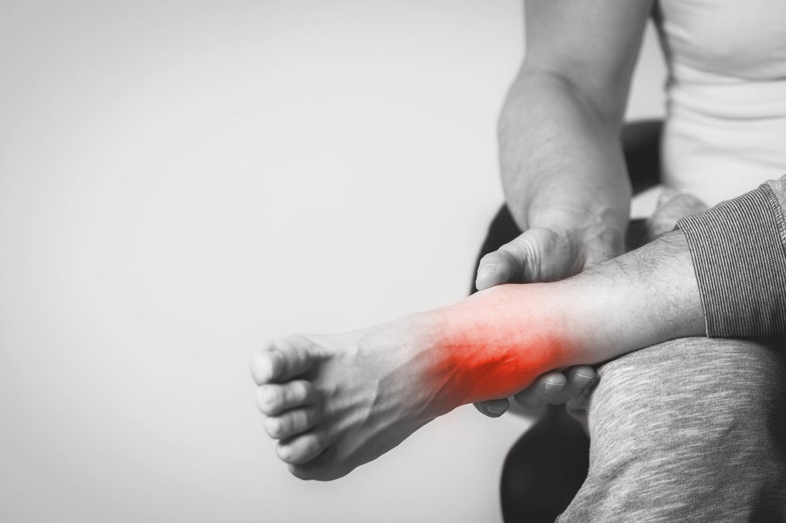 Persona con dolor visible en el tobillo, indicando una posible lesión o esguince alto
